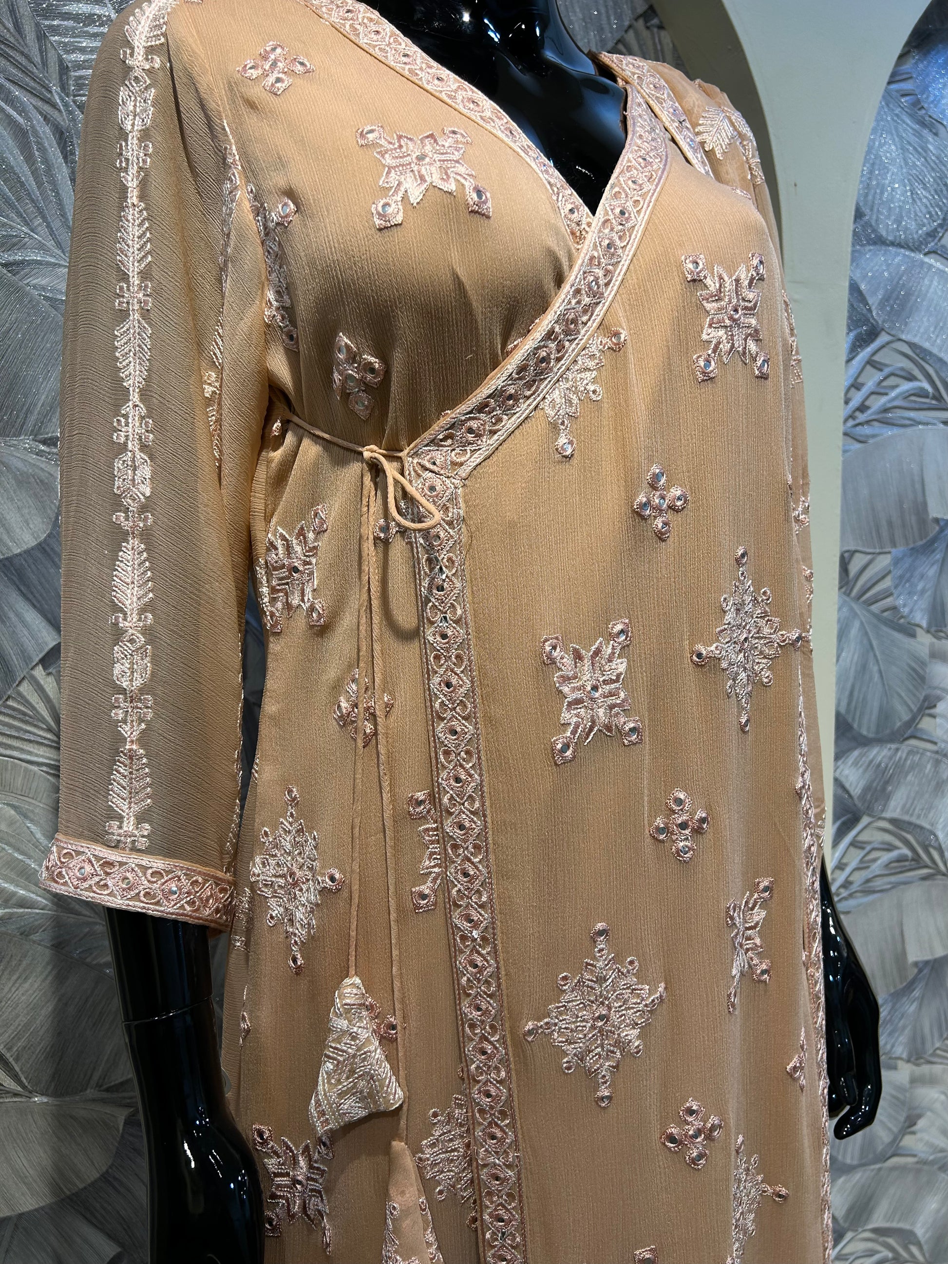 Peach chiffon wrap-style suit with thread embroidery, tassel tie detail, and matching embroidered dupatta