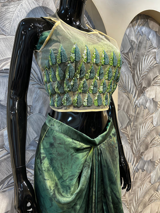 Green silk drape skirt with net blouse embellished in sequin leaf motifs, designed for party wear
