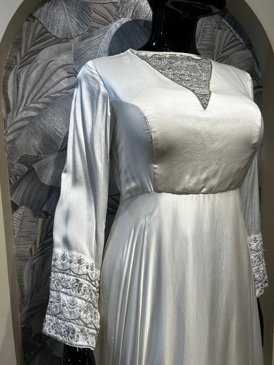 White satin gown with embroidered neckline yoke and wide embellished cuffs, full-length flowy design